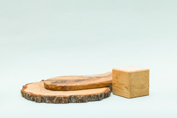 Abstract pastel background with wooden geometric shape and podium. Round wood saw cut cylinder form and cube box for eco product. Empty showcase in minimal style.