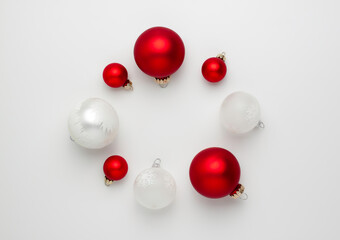 White and red balls make a Christmas wreath and change places isolated on white background from above. Flat lay holidays with copy space