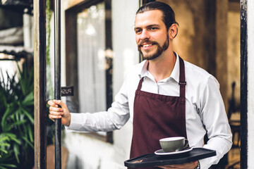 Portrait of handsome bearded barista man small business owner smiling outside the cafe or coffee...