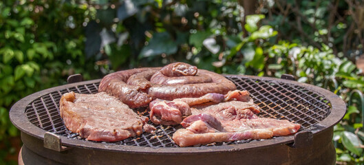Traditional South African braai barbecue with red meat roasting over coals in an outdoor fireplace