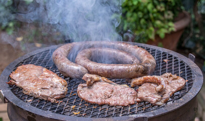 Traditional South African braai barbecue with red meat roasting over coals in an outdoor fireplace