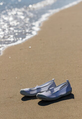 Fototapeta na wymiar リゾート地のビーチにある子供の上靴の風景