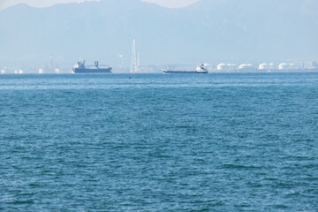 Fototapeta na wymiar 青空と伊勢湾の輸送用の貨物船の風景