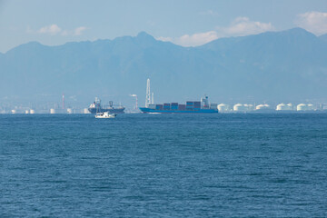 青空と伊勢湾の輸送用の貨物船の風景