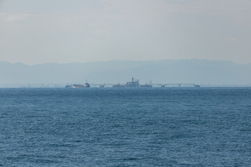 青空と伊勢湾の輸送用の貨物船の風景