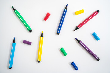 Colorful marker pens with caps removed on a white background. Close-up photo. - obrazy, fototapety, plakaty