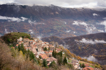 Fototapeta na wymiar italian mountain town upon the valley in autumn and the first snow
