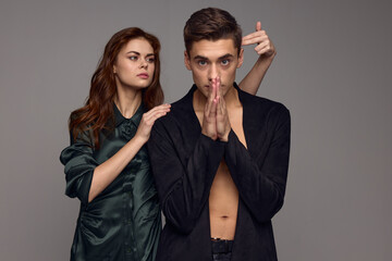 a man in a sweater joined his hands near his face and a woman with two fingers at the temple