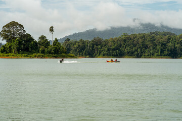 Fototapeta na wymiar People enjoying water activities on a banana boat at the Kenyir Lake, Terengganu.