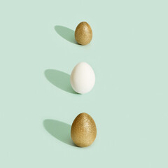 Decorated Easter golden and white eggs on green background. Happy Easter card, postcard, template with copy space.