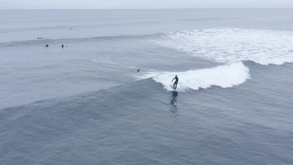 Easy going waves in freezing waters of iceland with surfers, aerial