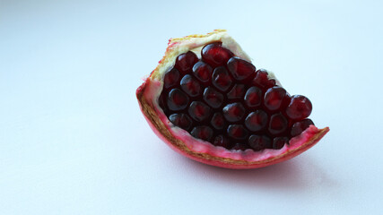 Slice of pomegranate isolated on white background. Healthy food, vytamins. Place for text. Selective focus.