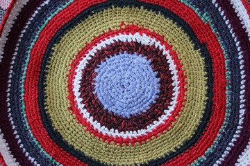 Background knitted rug from multi-colored threads around. Place for text. Selective focus. view from above