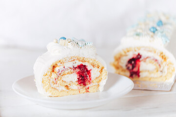 A cut piece from a white roll cake with a cherry filling on against a white background. Christmas mood. Sweets for any occasion.