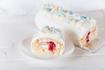 A cut piece from a white roll cake with a cherry filling on against a white background. Christmas mood. Sweets for any occasion.