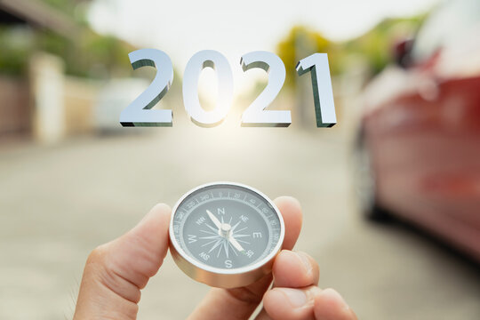 Man hand holding compass on city  blurred background Using wallpaper or background travel for happy new year 2021 image.For welcome new year photo.