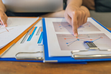 Young businesswoman comparing financial documents at office