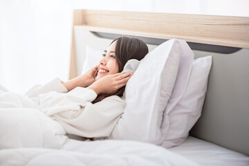 Happy asian woman enjoy listening to music with headphone or earphones in bedroom, happiness and relaxation concepts