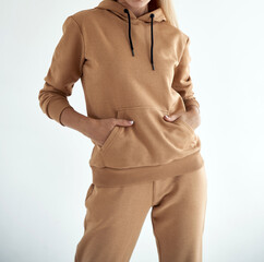 girl wears light brown hoodie and pants. isolated photo of women wearing nude color fleece textile...