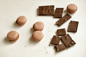 coffee macaroons on a white table with dark chocolate. Nice snack for tea. Delicious and cute gift set. Warm flatley made of chocolate and macaroons