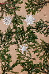 Christmas decorations flat layout with many fir branches on the cardboard background. Eco-friendly christmas ornaments. Scandinavian christmas cards with fir branches and snowflakes.