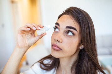 Woman using eye drop, woman dropping eye lubricant to treat dry eye or allergy, sick girl treating...