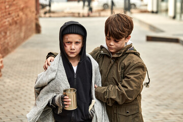 two homeless children ask for help in the street, at street in big city, begging. shelter concept.