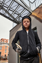 portrait of unhappy street boy alone outdoors, caucasian child has dirty face and clothes, dramatic portrait of a little homeless boy, dirty hand, poverty, city, street