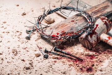 Old wooden cross, hammer, bloody nails and crown of thorns on ground. Banner. Copy space. Good...
