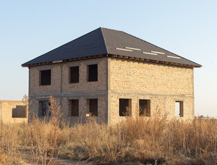 unfinished two-story brick house in nature