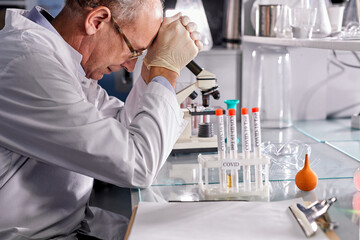 side view on tired man scientist,crashing, with failed experiments and working long hours, sit...