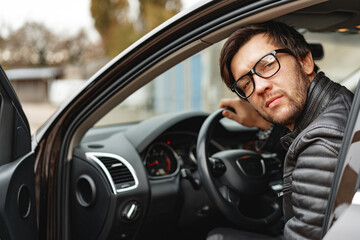 Confident young man sitting in a car