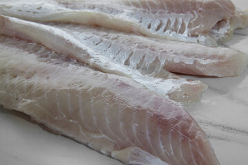 Gastronomy. Raw and healthy cooking ingredients. Closeup view of sliced white salmon meat steaks on the kitchen table.