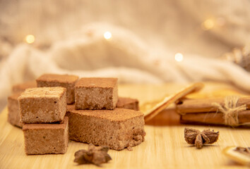 Fragrant spices and homemade marshmallows on a wooden tray, decorated with festive garland.