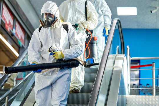 disinfectors are going to clean disinfect the building, go on escalator, coronavirus and covid-19 concept