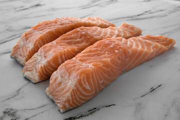 Culinary. Fresh seafood products. Closeup view of sliced raw salmon steaks on the white table. 