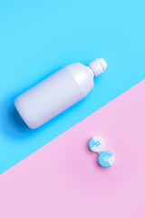 Container with contact lenses and  solution on color background