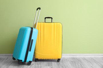 Packed suitcases near color wall