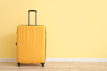 Packed suitcase near color wall
