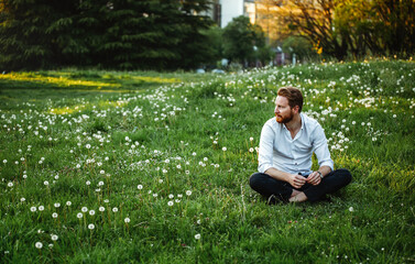 Naklejka na ściany i meble Happy young man rest on meadow. Nature, people concept