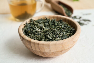 Bowl with dry green tea on light table