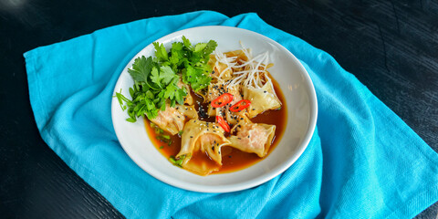 Boiled meat dumplings with fresh parsley, soy sauce and sesame seeds. Delicious meal for dinner.