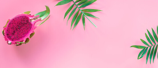 Fresh organic pink dragon fruit, pitaya or pitahaya with pink middle. Trendy banner, flat lay. Panoramic image on pink background with copy-space.. - Powered by Adobe