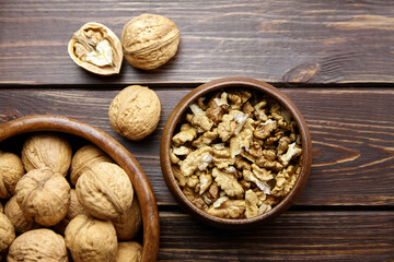 Walnut half and seeds and bowl on wooden table