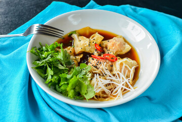 Boiled meat dumplings with fresh parsley, soy sauce and sesame seeds. Delicious meal for dinner.