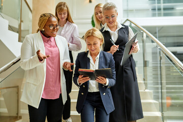 team of diverse women colleagues on stairs talking, discussing business ideas and strategies. business people, cooperation concept