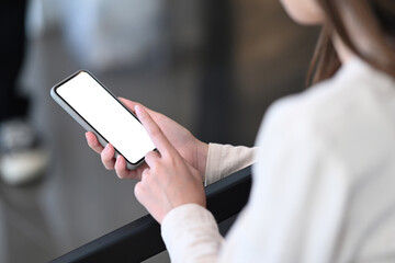 Cropped shot of young woman hands holding smartphone with blank screen clipping path inside.
