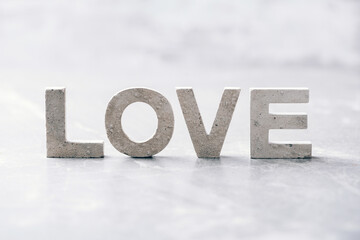 Word LOVE made with cement letters on grey marble background. Copy space. Biblical, spiritual or christian reminder