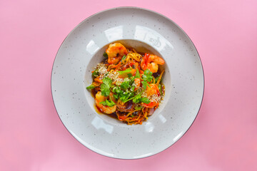 Asian noodles with shrimps, asparagus and sesame seeds. Delicious shrimp wog, traditional Asian cuisine.