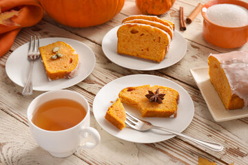 Tasty pumpkin pie with tea on table